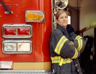 Female firefighter next to a fire truck